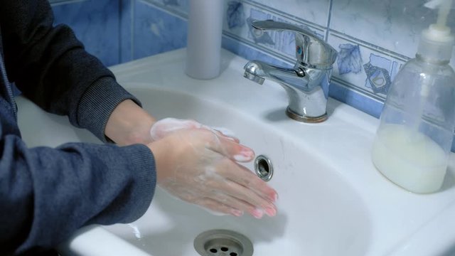Child boy washing hands with antibacterial soap in sink, hands closeup. Fighting spread of coronavirus infection covid-19. Hygienic procedures at home on quarantine and isolation during pandemic.