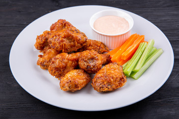 Fried legs and wings with breading, served with sauce and vegetables