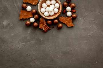 Sweets background with chocolate praline balls on grey desk top-down frame copy space