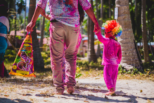 kid and father walking holding hands during holi in havelock