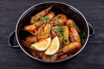 Fried shrimp on oil, served with greens and lemon