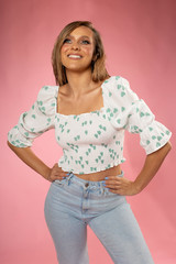 Beautiful blonde woman posing in white shirt with green hearth and blue jeans