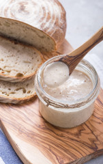 Fresh homemade bubbly sourdough starter, a fermented mixture of water and flour to use as leaven...