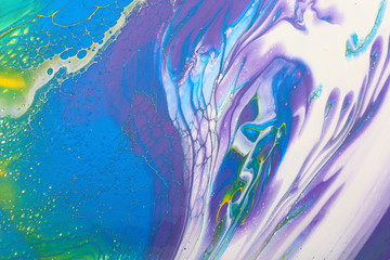 art photography of abstract marbleized effect background. Yellow, gold, blue, purple, pink and white creative colors. Beautiful paint