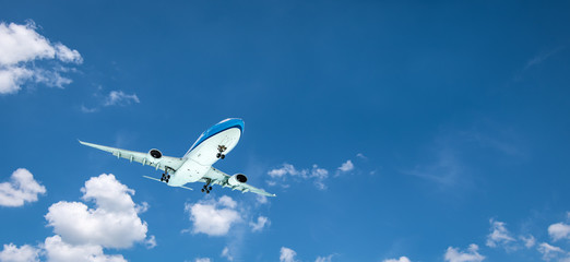 Fototapeta na wymiar Airplane flying in the blue sky. Travel and transportation banner background.