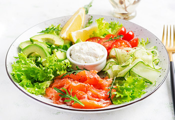 Salad of salted fish salmon, avocado, cherry tomatoes, cucumber, lettuce and cream cheese. Fish menu. Dietary menu. Seafood - salmon.