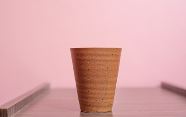 Cup on pink pastel background.