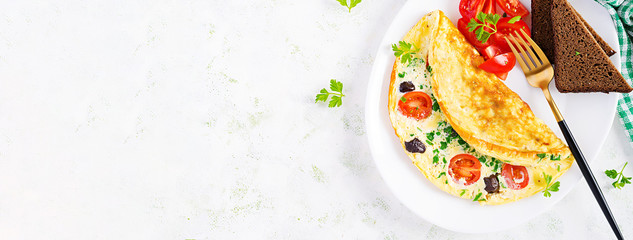 Breakfast. Omelette with tomatoes, black olives, cottage cheese and green herbs on white plate.  Frittata - italian omelet. Top view, banner