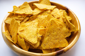 a bowl of corn chips nachos close up on a white background