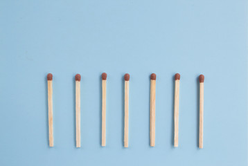matches in a row on a blue background, down arrow from matches. Top view. Mock up. Flat lay composition