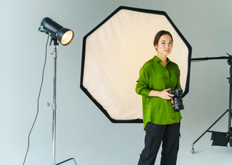 Young photographer at studio. Asian woman in photography studio.