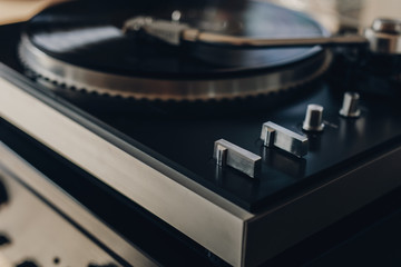 Vinyl record player with a record album and an amplifier. Cozy and warm atmosphere at home.