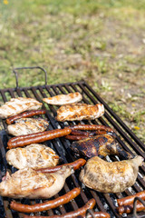 Chicken meat and smoked sausages on the grill