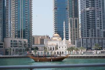 Fototapeta premium Dubai city skyline and marina with a traditional yacht 