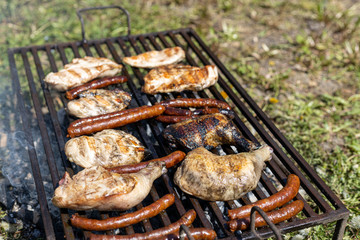 Chicken meat and smoked sausages on the grill