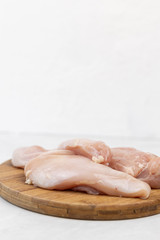 Chicken raw white meat on the wooden kitchen board with copy space
