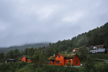 Norwegian landscape with houses with earth on their roofs and grass growing