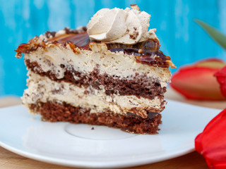 Beautiful delicious cake on a white plate, blue background
