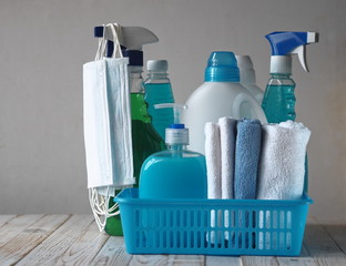 Coronavirus. The idea of general cleaning of the house during quarantine. Medical protective mask on cleaning products and cleaning tools. Spend time at home with benefits for the home. Side view.