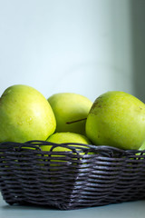 green apples in basket on the table