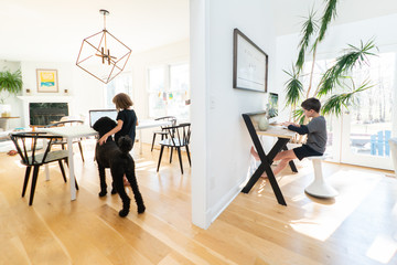 Children working on computers in different rooms at home