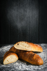Traditional french baguettes on a dark background top view copy space.