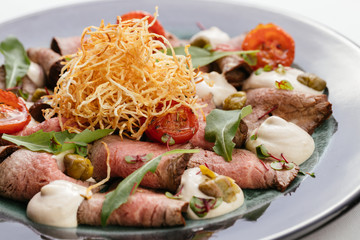 Lunch of meat and vegetables with baked cheese.