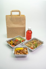 Paper bag foil containers and mors on an isolated background. Contactless food delivery during the quarantine period. © Ekaterina_1525