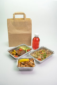 Paper bag foil containers and mors on an isolated background. Contactless food delivery during the quarantine period.