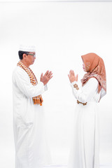 portrait lovely senior asian muslim married couple. embracing each other and going for ramadan eid mubarak celebration concept isolated over a white