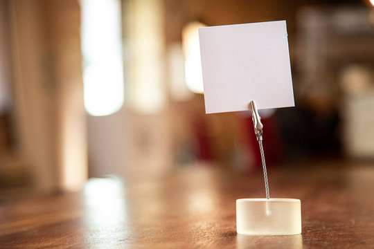 biglietto in bianco su un tavolo in legno isolato su sfocato su  interno di un locale