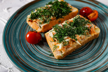 A couple of vegetable sandwiches on fresh white bread with cheese, carrots and crab meat, decorated with dill greens, next to cherry tomatoes and a fragrant garlic smell of snacks