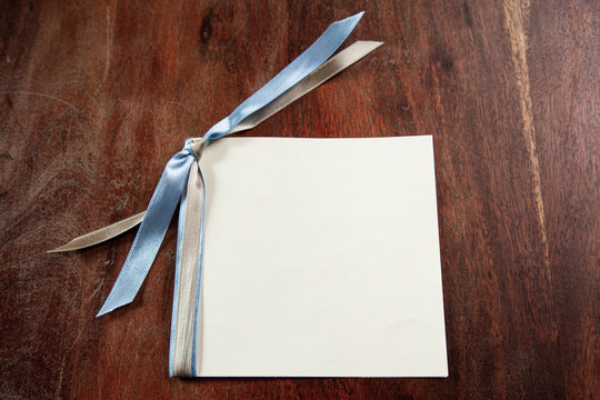 biglietto con fiocco azzurro in bianco su un tavolo in legno i