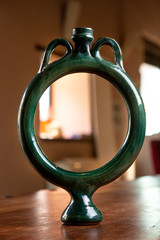 Vaso artistico  in ceramica rifinito e poggiato su un tavolo dentro una  casa 
