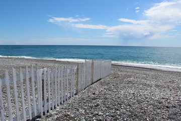 Fototapeta premium Rocky beach with white, wooden fence near ventimiglia