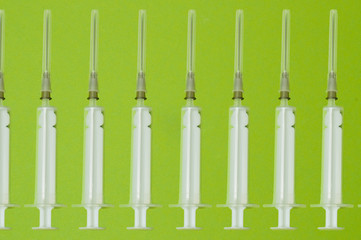 Pattern, medical syringes on a green background