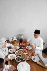 iftar dinner on ramadan. muslim asian family breaking the fast together