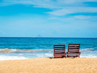 Chairs on the beach near ocean. Winter vacation in hot places. Sunshine and moody sky