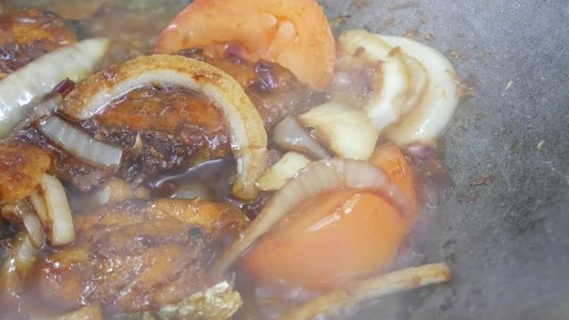Fried Spanish mackerels fish cooked with black soy sauce. The Spanish mackerels pieces are fried over dry and then poured with soy sauce and onion.