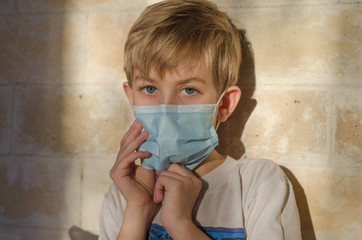 A child with a medical face mask. Protecting the child from Coronavirus and other respiratory diseases. Young children use medical face masks to protect their health.