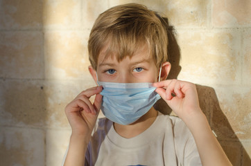 A child with a medical face mask. Protecting the child from Coronavirus and other respiratory diseases. Young children use medical face masks to protect their health.