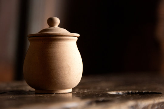 contenitori in terracotta con coperchio sopra tavolo in legno 