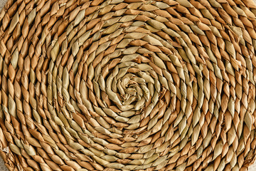 Wicker stand for hot dishes. Pattern of straw. Top view.