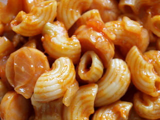 Closeup - Stir in Macaroni with Tomato Sauce. Selective Focus