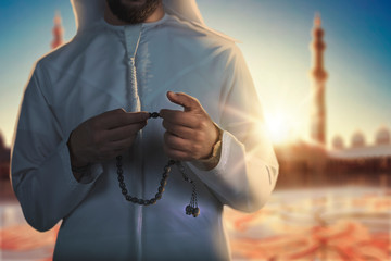 Arab Muslim man holding islamic rosary,.standing inside a big mosque..ramadan Kareem Islam religion, holy month.