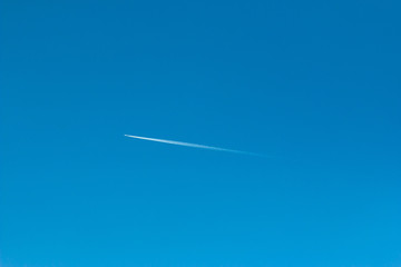 traces of an airplane in the blue sky