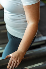 cropped view of overweight girl exercising in sports center