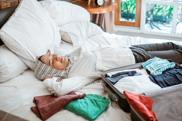 muslim woman with scarf relaxing while packing at home