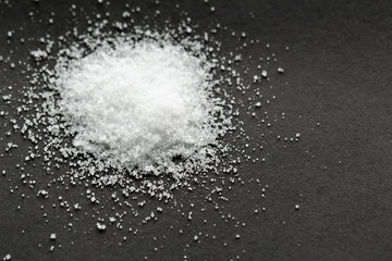 White sea salt on black background