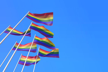 Gay pride flags waving in the wind against a blue sky. 3D Rendering